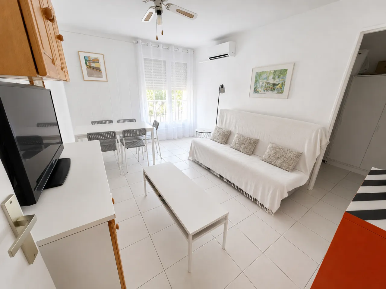 Pièce de vie de l'appartement à Bormes-les-Mimosas : canapé-lit, coin repas et télévision